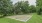 Sand volleyball court surrounded by trees