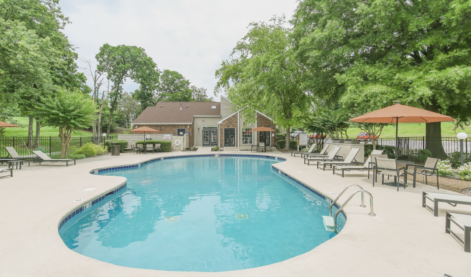 Pool with sundeck and orange umbrellas